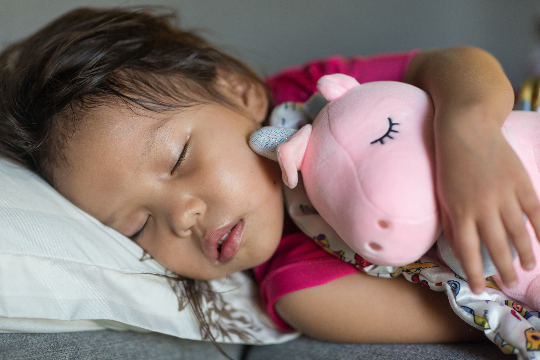little girl sleeping with stuffed animal.
