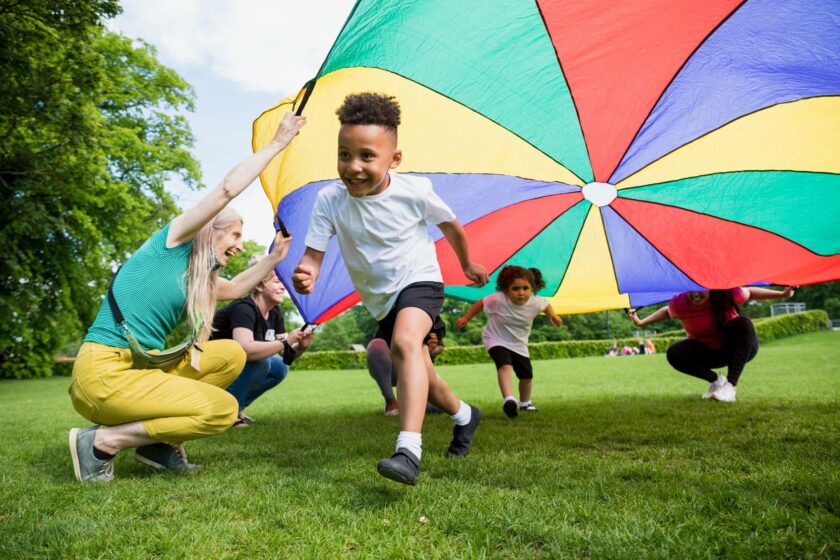 Child playing under a parachute.